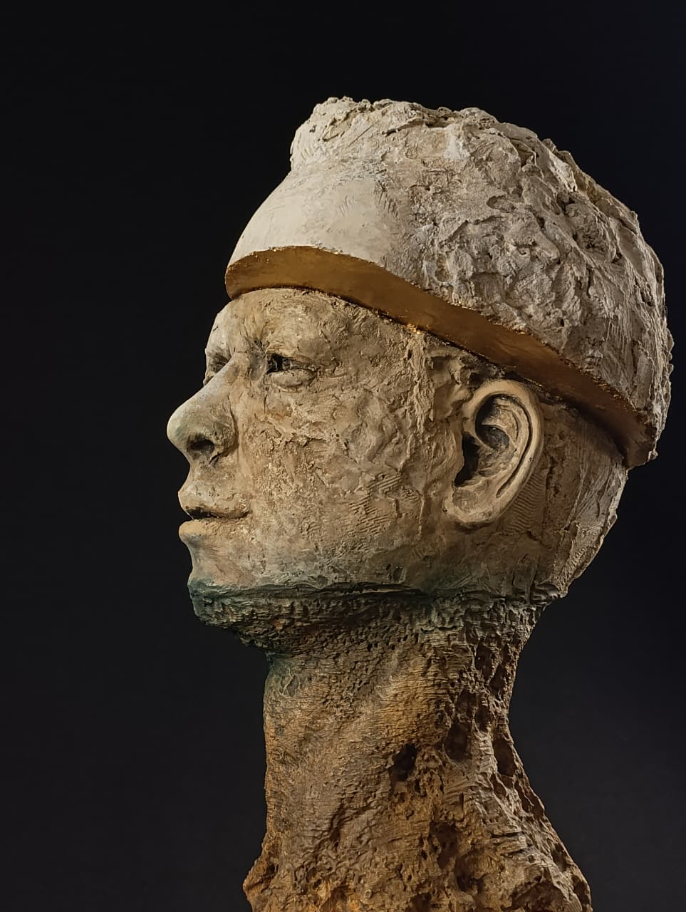 Primer plano del rostro humano emergiendo de la piedra natural con textura erosionada.