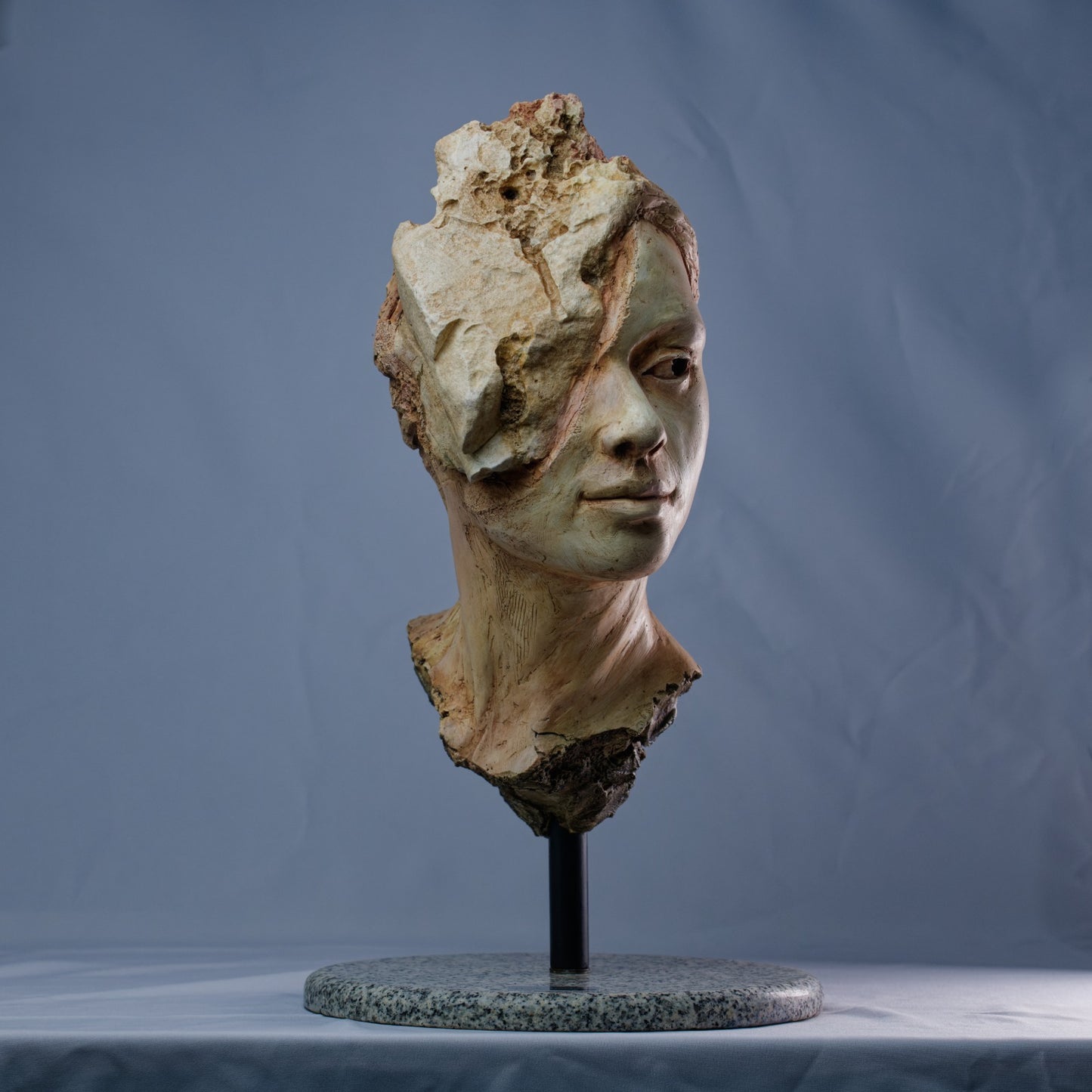 Escultura femenina en ferrocemento con textura erosionada – Paciencia.