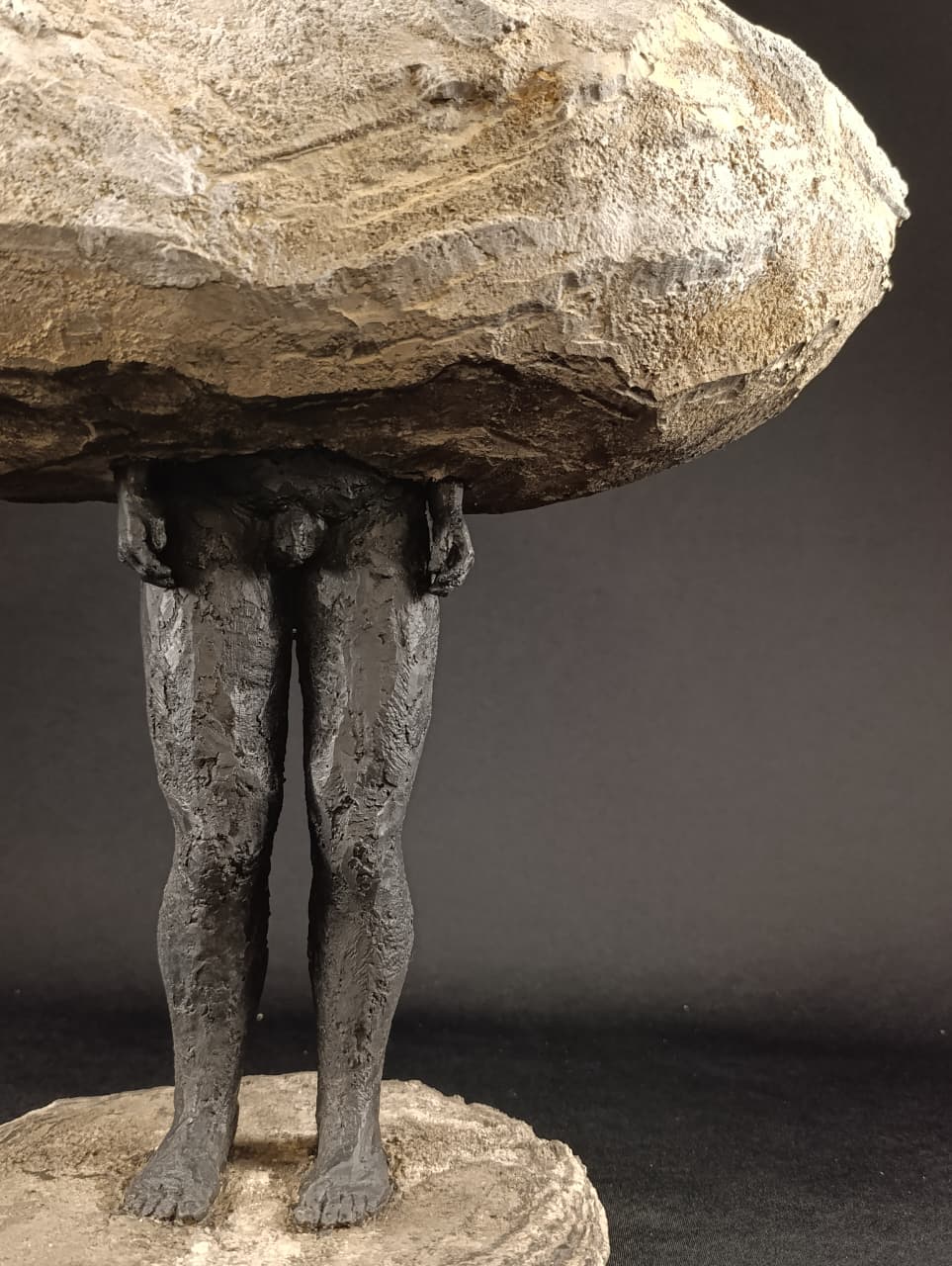 Escultura Sobrepeso, detalle de la figura masculina y base, perspectiva inferior