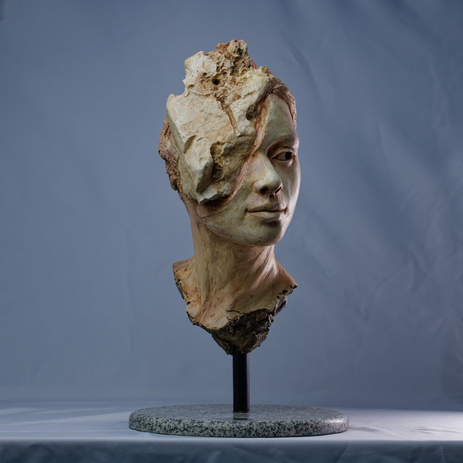 Escultura femenina en ferrocemento con textura erosionada – Paciencia.