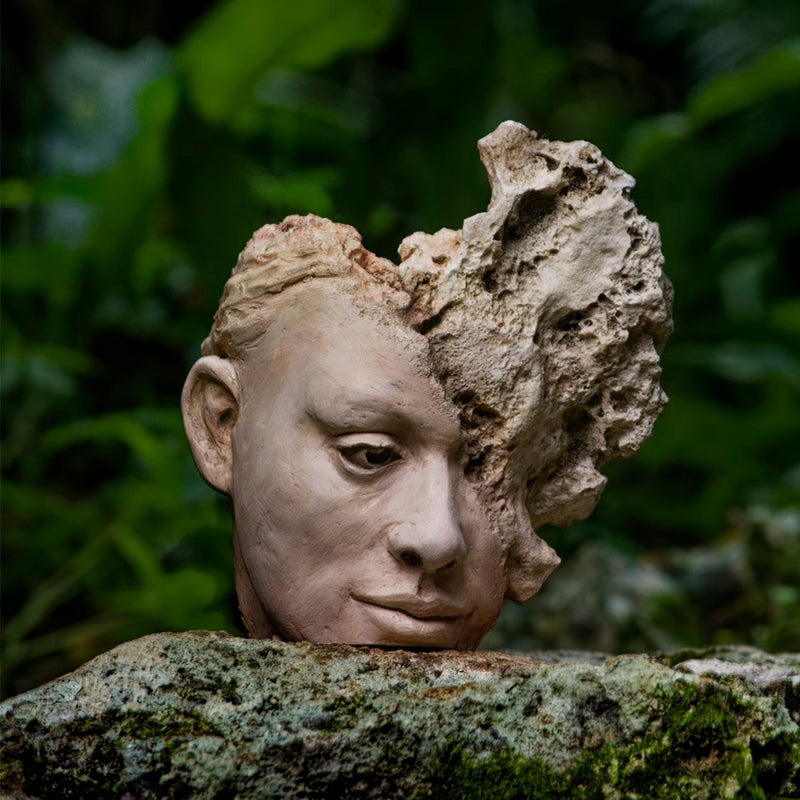Escultura Silencio de Carlos Becerra Llabrés – cabeza femenina con rostro transformado en roca y coral.